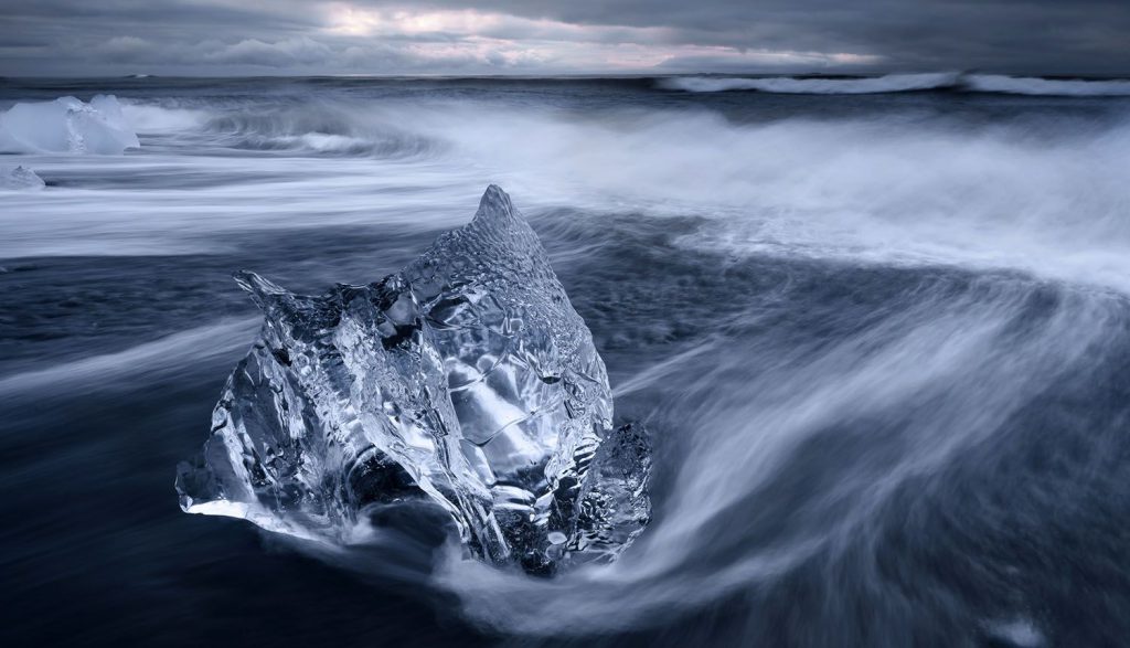 یک کوه یخی درخشان عکاسی شده در ساعات آبی